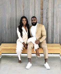 a man and woman sitting on a wooden bench