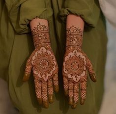 two hands with henna designs on them