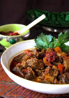 a white bowl filled with meat and vegetables