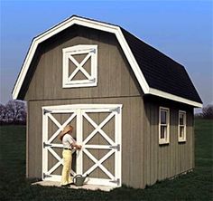 a man is standing in the doorway of a barn with his hands on the door