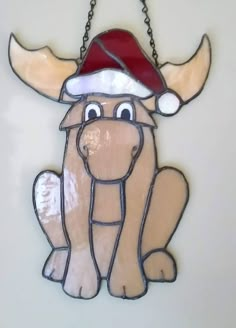 a stained glass dog with a santa hat on it's head hanging from a chain