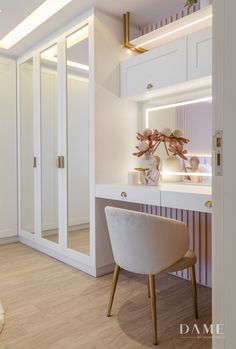 a white desk and chair in front of a mirror with lights on the wall behind it