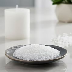 white sugar on a plate next to a candle