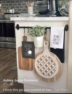 kitchen utensils and cutting boards are hanging on the wall in front of the stove