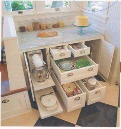 an open drawer in the middle of a kitchen