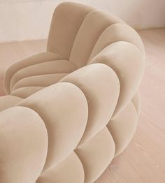 an upholstered chair sits on the floor in front of a wall