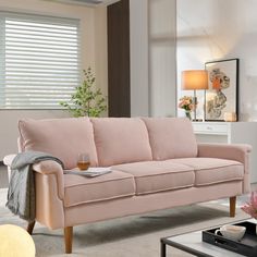 a living room with a pink couch and coffee table