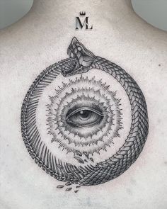 a man's back with an all seeing eye tattoo on it