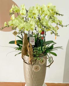 a vase filled with yellow flowers on top of a wooden table next to a wall