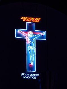 the neon sign for jesus the light of the world is lit up in blue and red