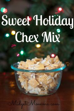 a glass bowl filled with chex mix sitting on top of a table next to a christmas tree