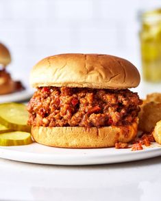 a sloppy joe sandwich on a plate with pickles