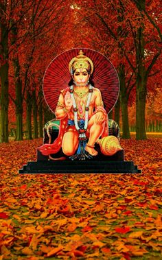 an image of the god ganesh in autumn with leaves on the ground and trees behind it