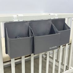 two storage bins on the side of a crib