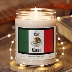 a candle with the flag of mexico on it sitting on top of a wooden table