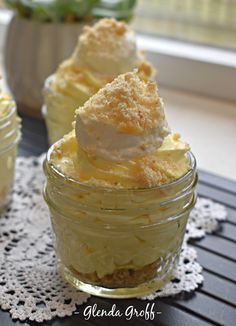 small jars filled with dessert sitting on top of a table