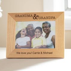 a wooden frame with the words grandma and grandpa on it is sitting on a table