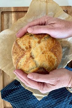 a person holding a loaf of bread in their hands