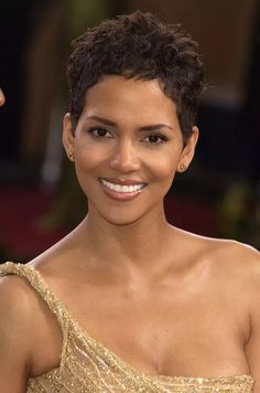 a close up of a person with a smile on their face and wearing a gold dress