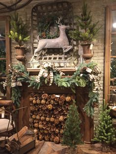 a fireplace decorated for christmas with pine cones and greenery