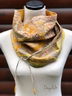 a white mannequin with a yellow and brown scarf on it's neck