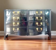 a mirrored dresser with gold knobs and drawers