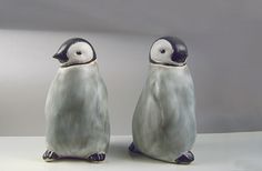 two ceramic penguins sitting next to each other