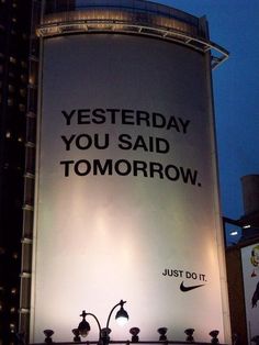 an advertisement on the side of a building that says, yesterday you said tomorrow just do it