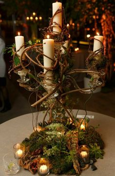 a table with candles and moss on it