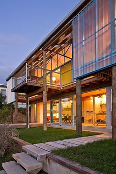 a modern house with glass walls and wooden steps