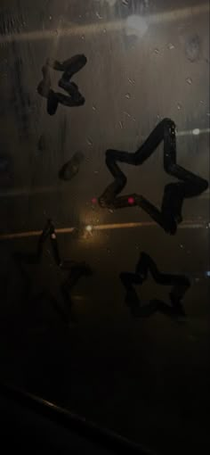 several pairs of shoes are reflected in the wet window glass on a rainy day at night