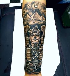 an egyptian tattoo on the arm with a pharaoh and moon in the sky behind it