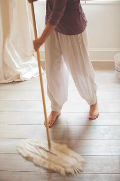 a woman is cleaning the floor with a mop