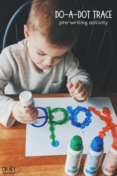 a little boy sitting at a table with some crafting supplies