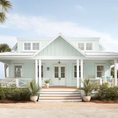 a white house with porch and steps leading to the front door