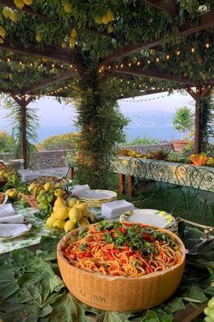 a large bowl filled with food on top of a table covered in fruit and vegetables