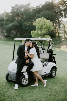 a man and woman kissing on the back of a golf cart