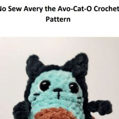 a crocheted blue and black cat with big eyes holding a piece of bread