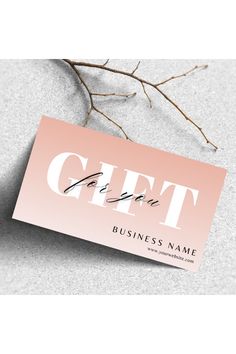 a pink and white business card with the word gift on it, next to some branches