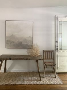 a wooden table sitting next to a chair on top of a rug