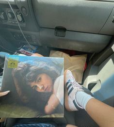 a person sitting in the back seat of a car holding an album