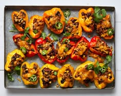 an overhead view of stuffed peppers with meat and vegetables on a baking sheet, ready to be eaten