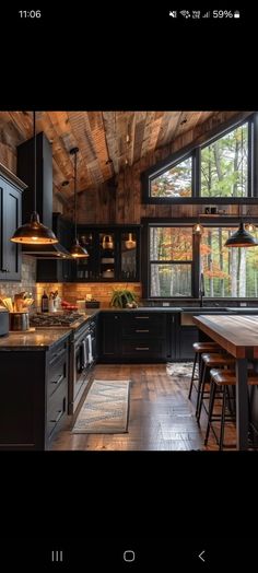 a kitchen with black cabinets and wooden floors is seen in this image from the inside