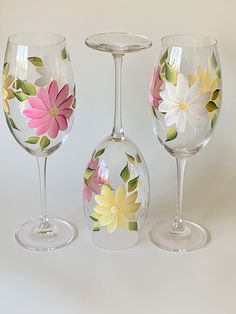 three wine glasses with painted flowers on them