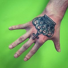 a person's hand with a tattoo on it and a jar in the middle