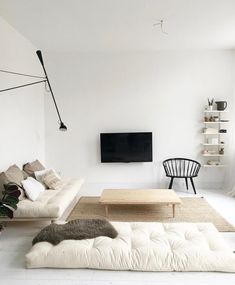 a living room filled with furniture and a flat screen tv mounted to the side of a wall