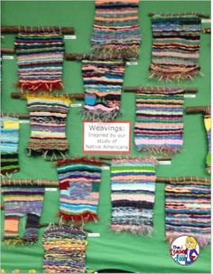 many different types of weavings hanging on a green wall in front of a sign