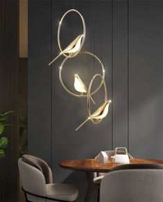 a modern chandelier hanging over a dining room table with two birds on it