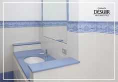 a bathroom with blue and white tile on the walls, sink and mirror in it