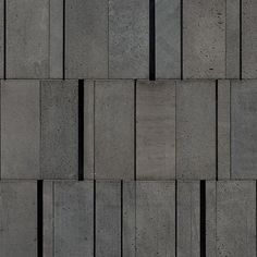 the side of a building made out of concrete blocks with vertical lines on each side